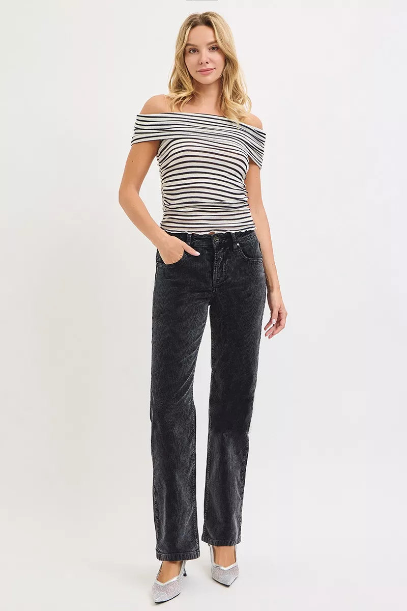 Woman wearing a black and white striped top and black jeans on a white background