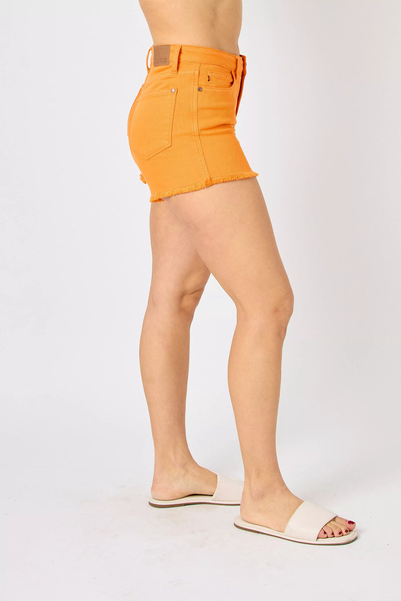 Person wearing bright orange shorts on a white background