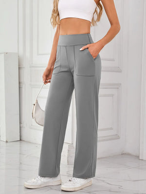 Person wearing gray high-waisted pants with a white background