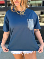 Woman wearing a blue t-shirt with a denim pocket design.