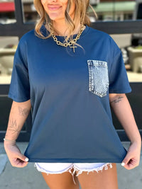Woman wearing a blue t-shirt with a denim pocket design.