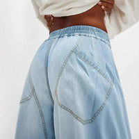 Light blue denim pants worn by a person on a white background