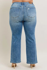 Blue jeans worn by a person on a plain background