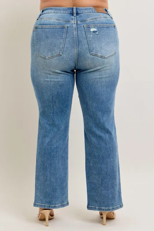 Blue jeans worn by a person on a plain background