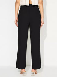 Black pants worn by a person on a white background