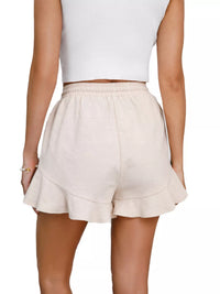 Beige shorts worn by a person on a white background