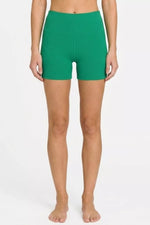 Person wearing green shorts on a white background