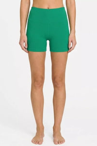 Person wearing green shorts on a white background