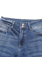 Close-up of blue denim jeans with stitching details on a white background