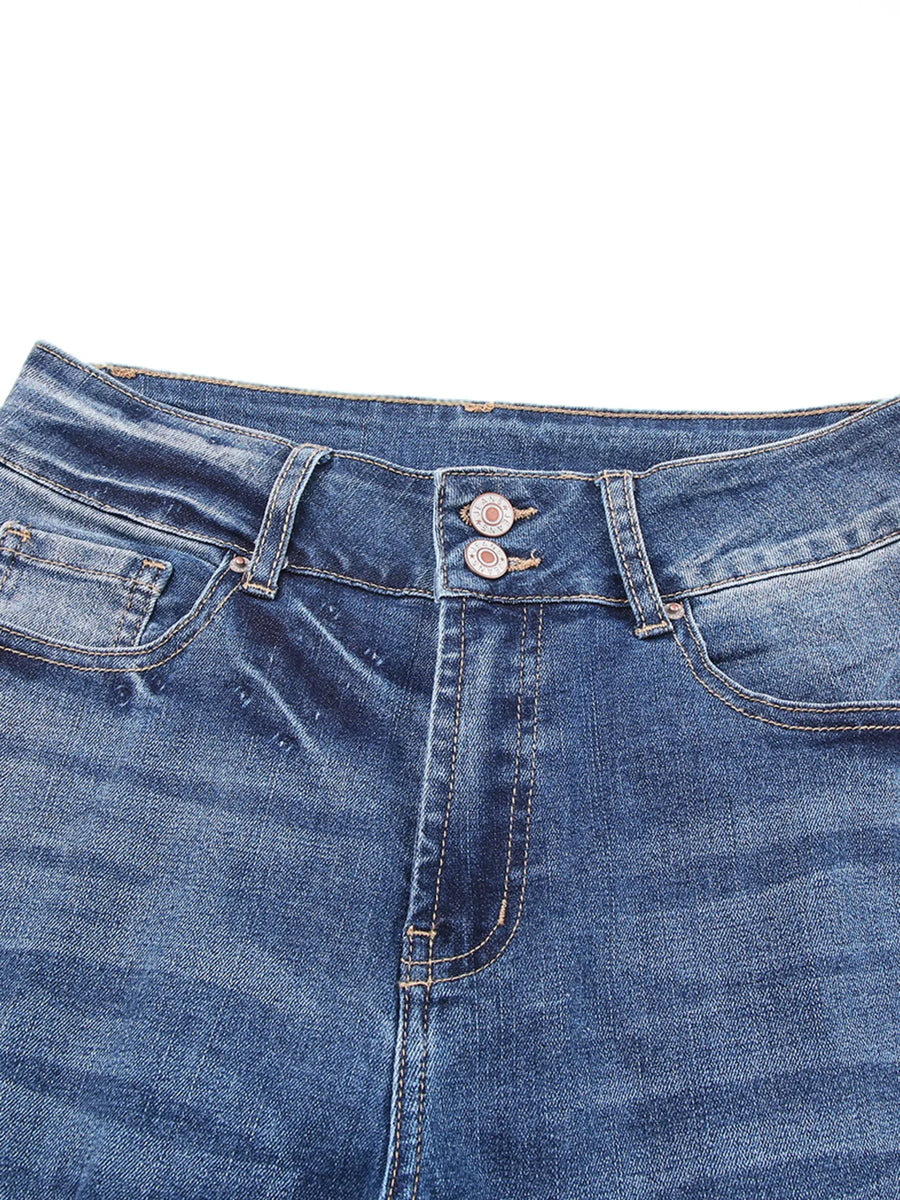 Close-up of blue denim jeans with stitching details on a white background