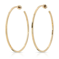 A pair of gold-colored hoop earrings with a square wire shape, displayed against a white background.