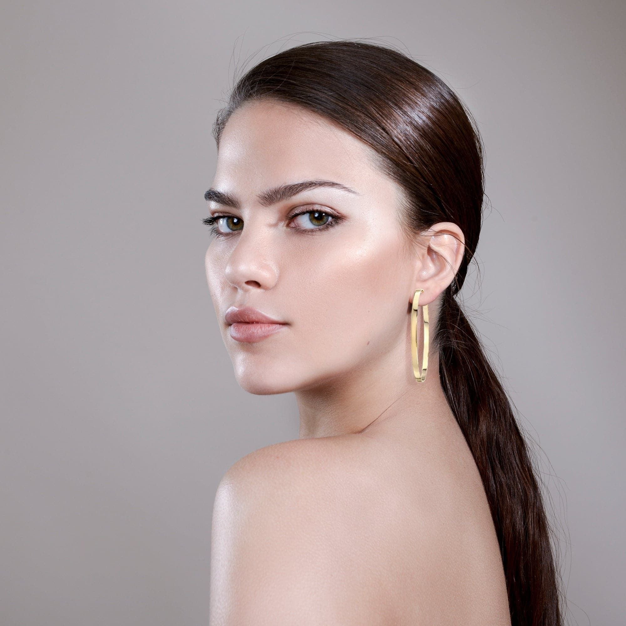 Woman wearing 2.5" Isla Hoops in her left ear