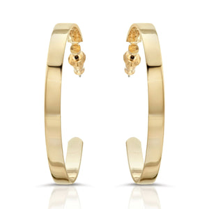 A pair of flat wide flat recycled brass hoop earrings with a 14k yellow gold finish.