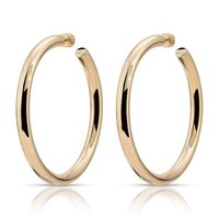 A pair of gold-colored hoop earrings with a reflective surface, placed against a white background.