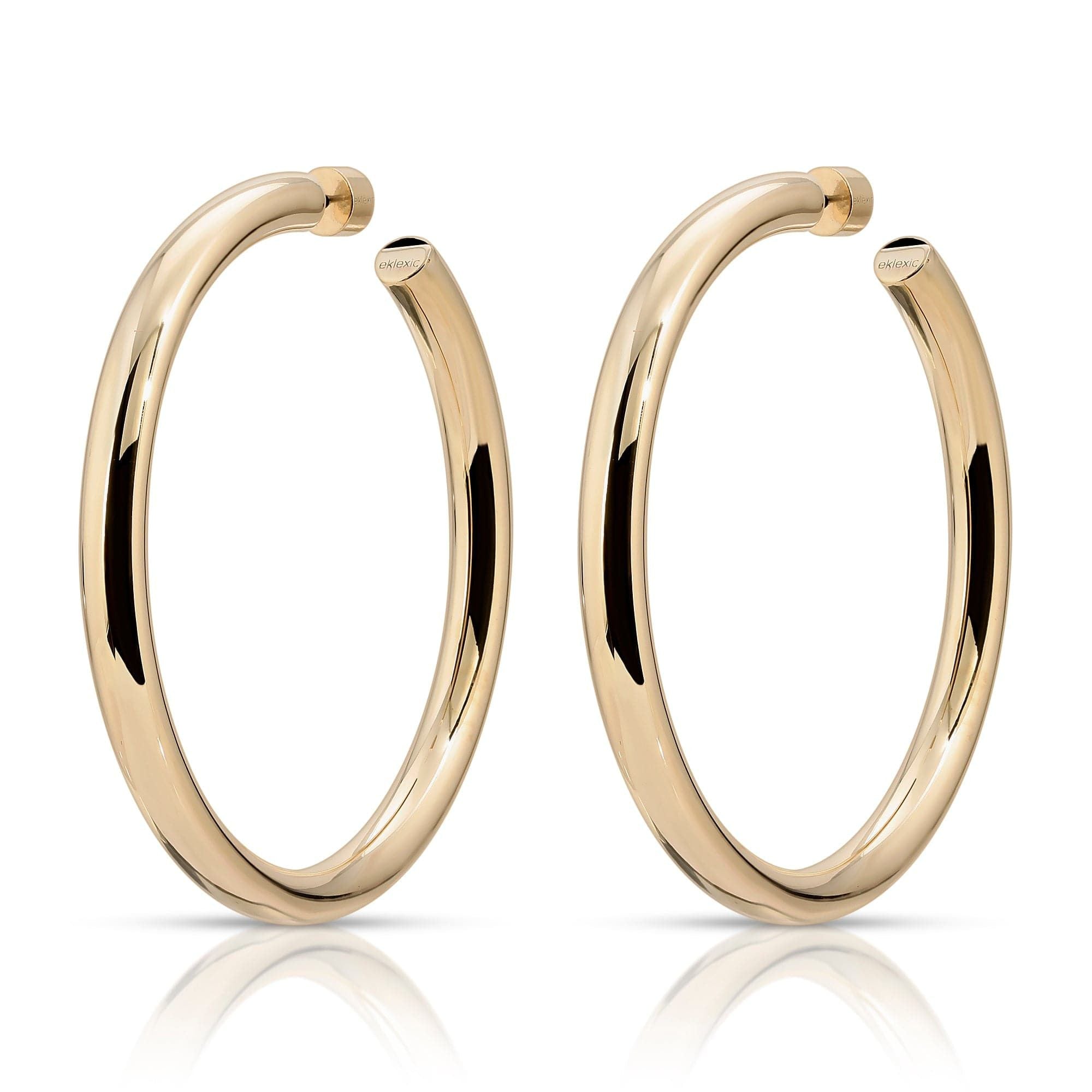 A pair of gold-colored hoop earrings with a reflective surface, placed against a white background.