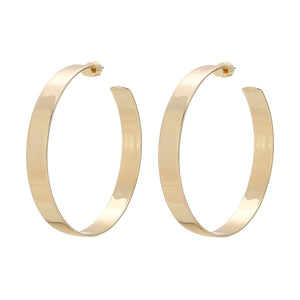 A pair of 2.5 inch flat recycled brass hoop earrings with a gold finish.