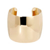 A gold-colored, slightly domed cuff bracelet with a high polish finish.