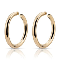 A pair of 2-inch gold-colored hoop earrings with a glossy finish.