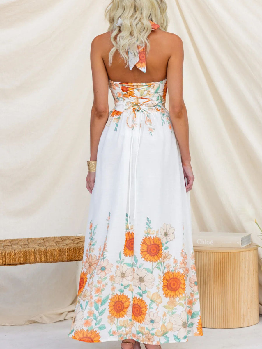 Woman wearing a strapless floral dress with orange flowers against a neutral background