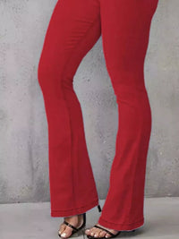 Red pants worn by a person against a gray concrete wall.