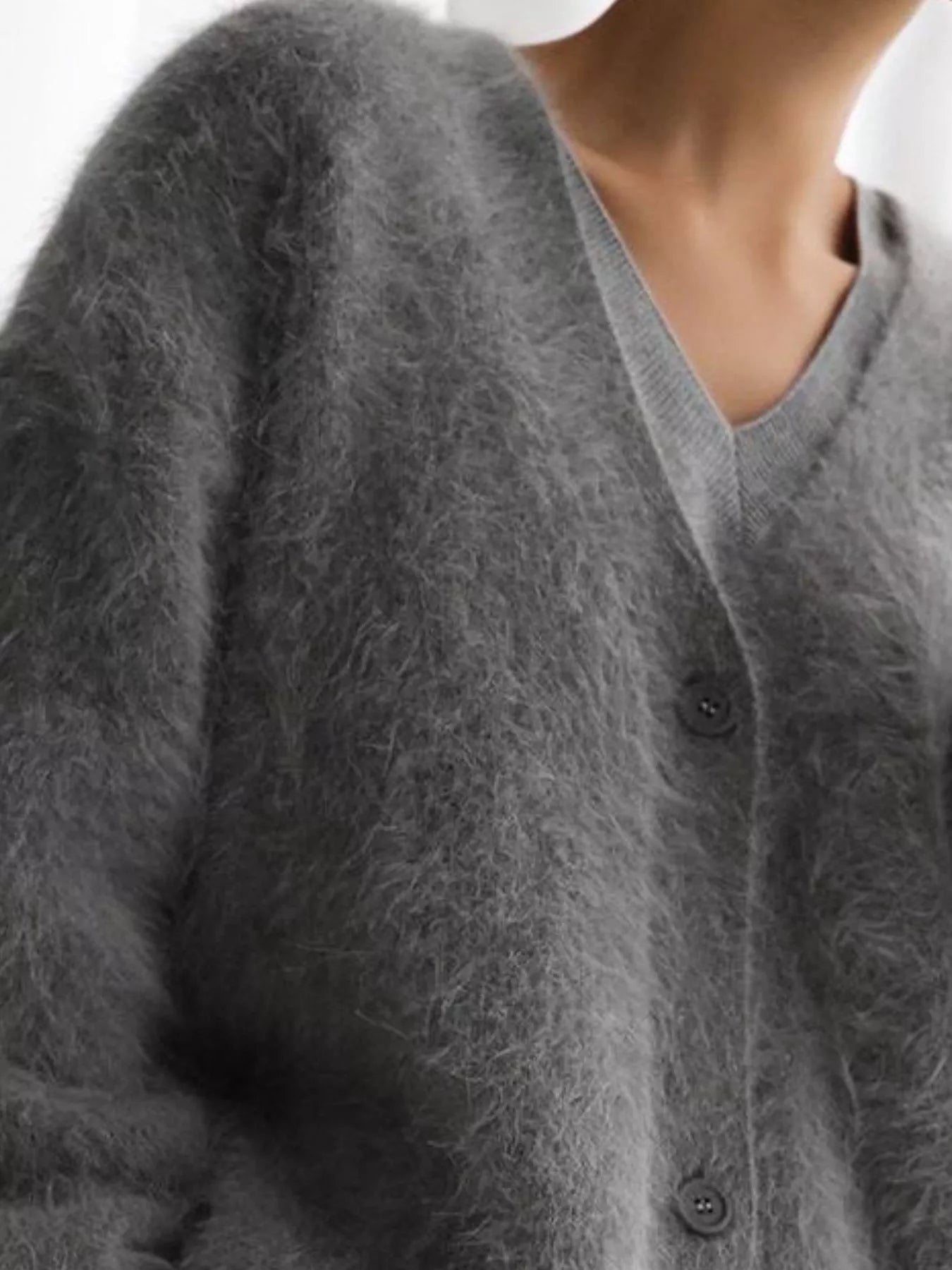 Close-up of a gray textured cardigan with buttons.