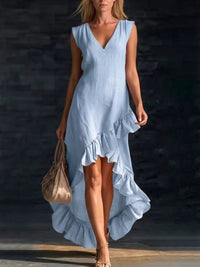 Woman wearing a light blue dress with ruffles against a dark background