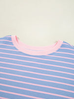 Close-up of a blue and pink striped shirt with a light green background