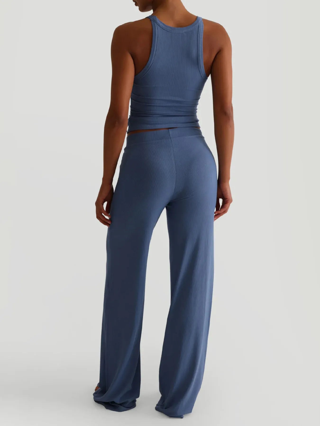 Person wearing a blue jumpsuit on a light gray background