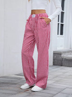 Person wearing red and white checkered pants standing on a stone patio.