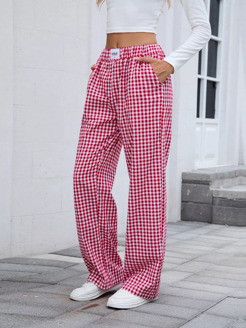 Person wearing red and white checkered pants standing on a stone patio.