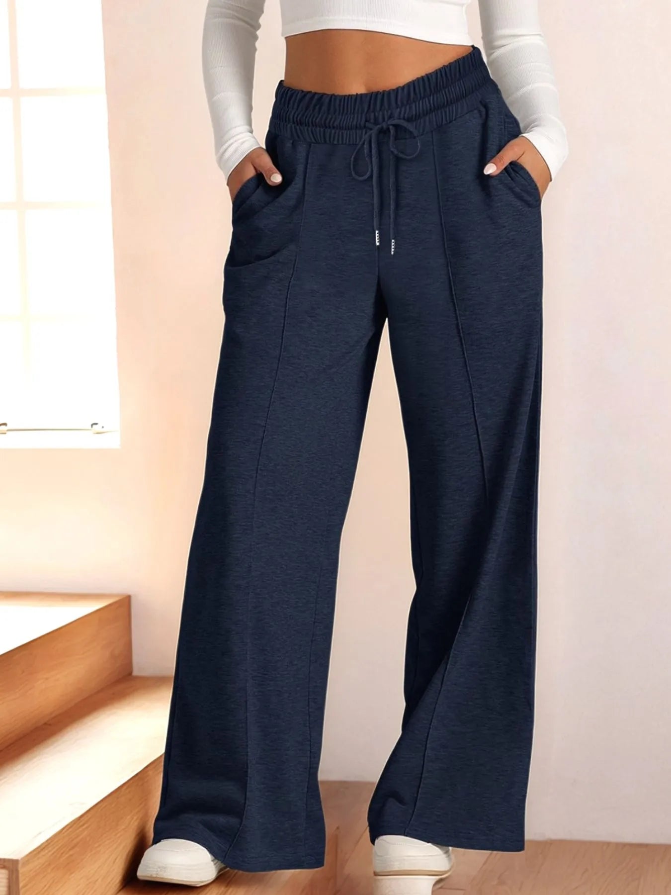 Navy blue wide-leg pants worn by a person indoors.