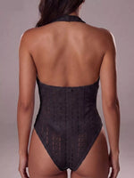 Black lace bodysuit worn by a model on a plain background