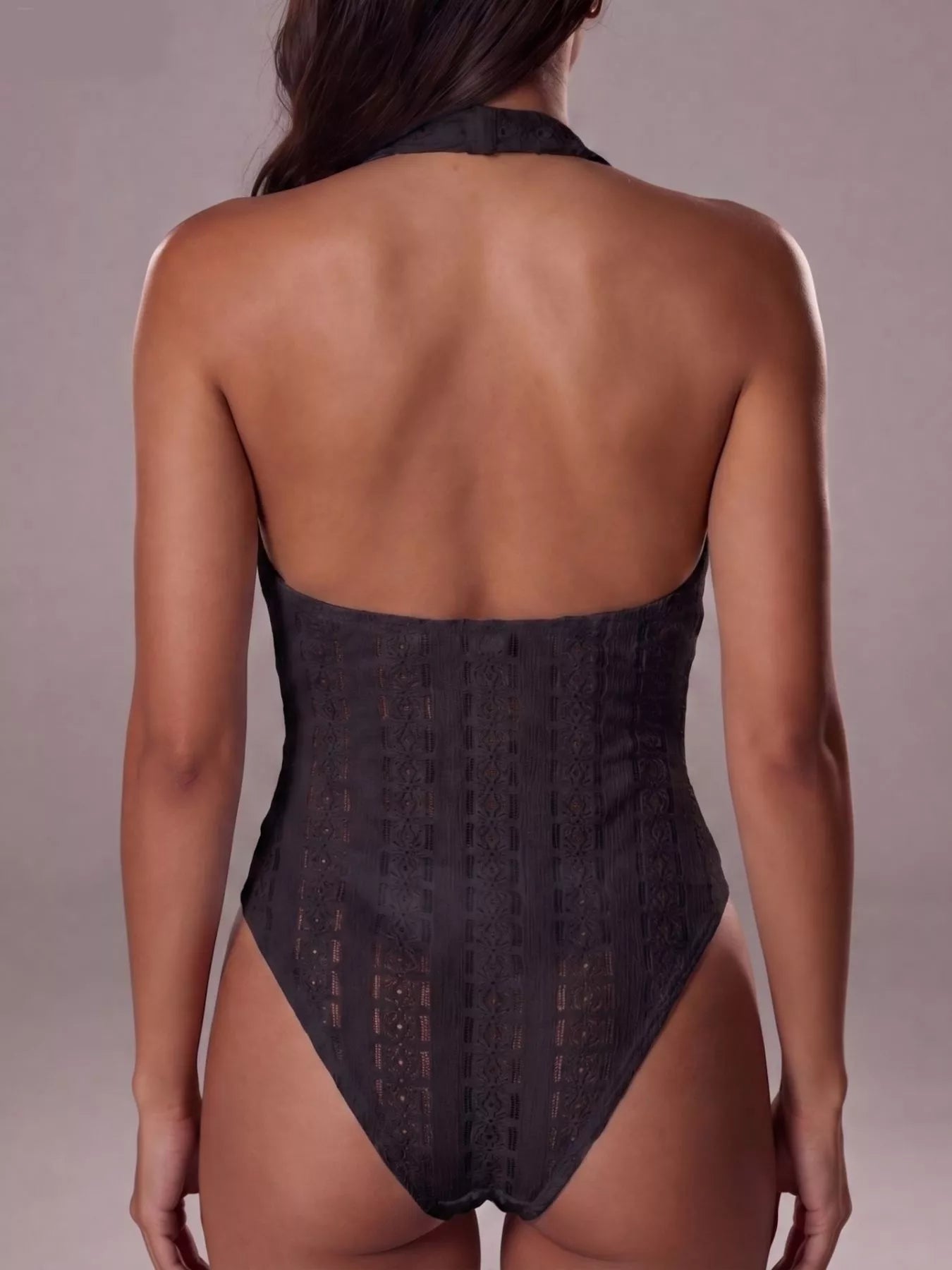 Black lace bodysuit worn by a model on a plain background