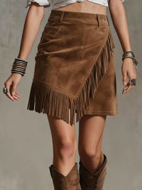 Brown suede fringe skirt worn by a person on a neutral background