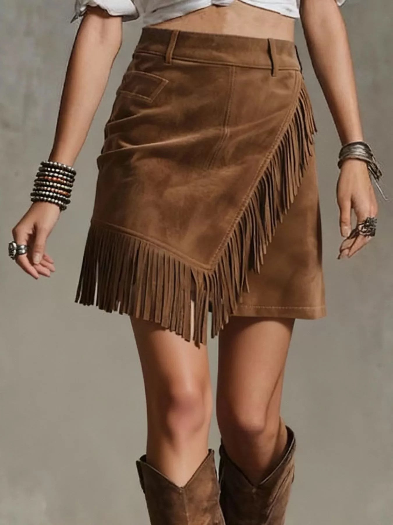 Brown suede fringe skirt worn by a person on a neutral background