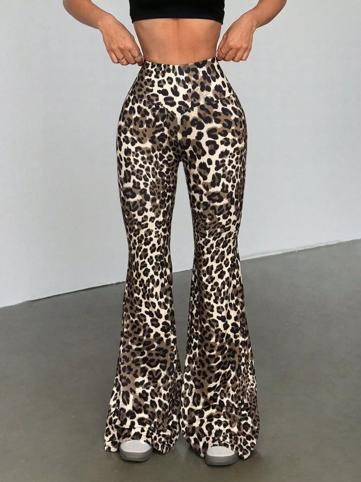 Leopard print flared pants worn by a person on a plain background
