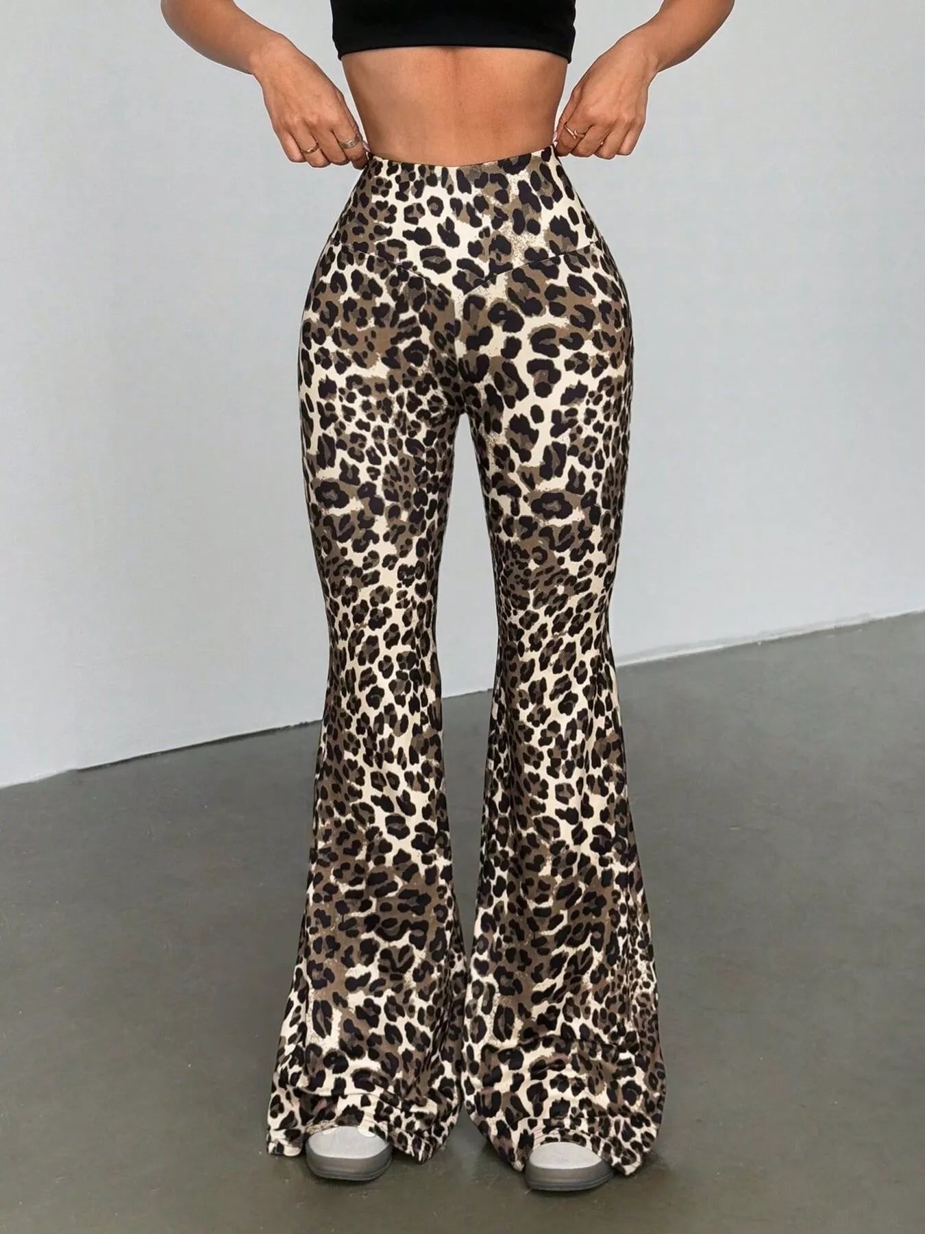 Leopard print flared pants worn by a person on a plain background