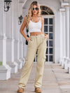 Woman wearing a white crop top and beige cargo pants on a staircase.