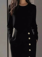 Black outfit with button details on a plain background