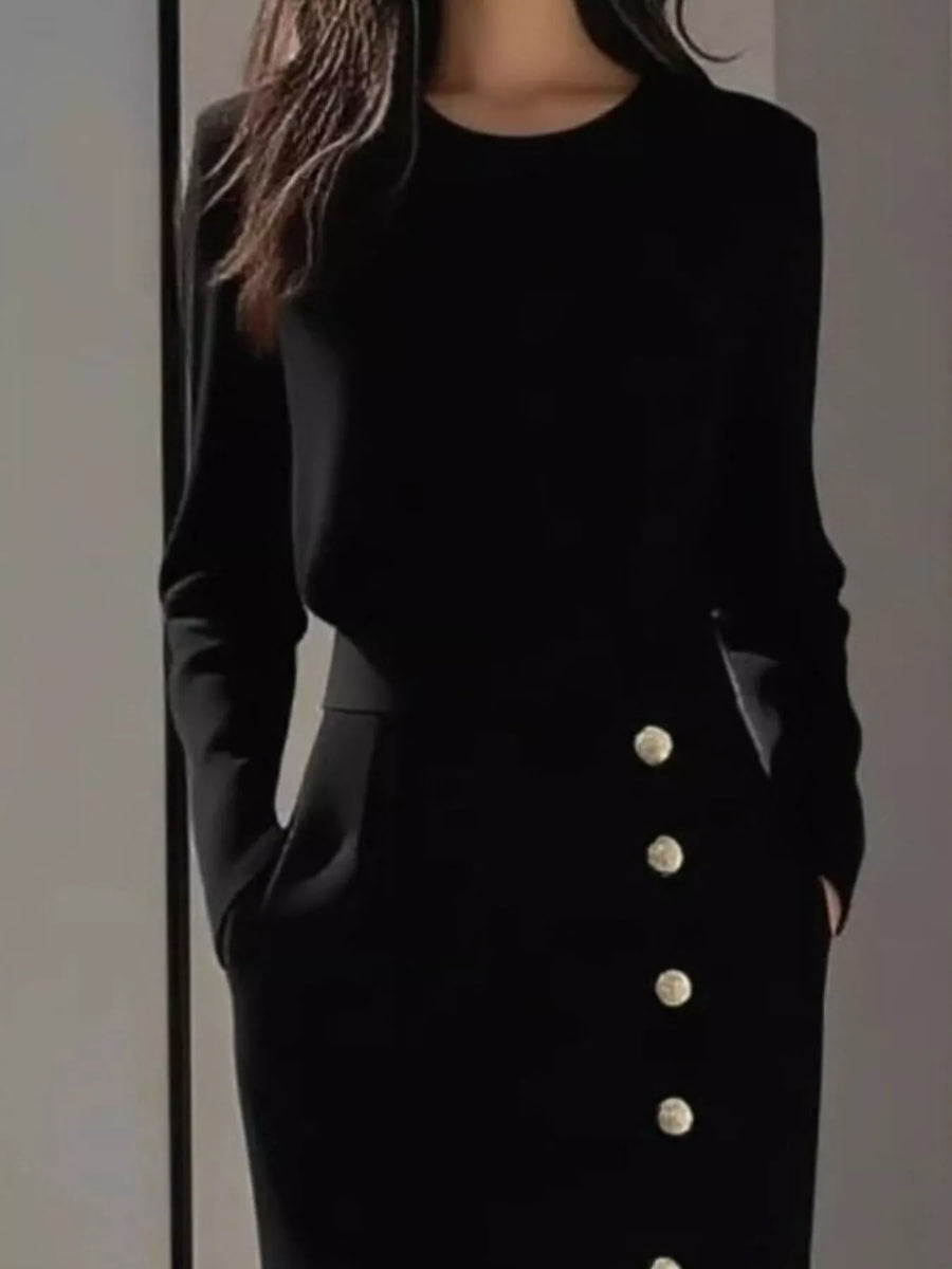 Black outfit with button details on a plain background