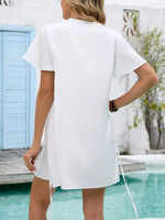 Woman wearing a white dress by a poolside with a blurred background