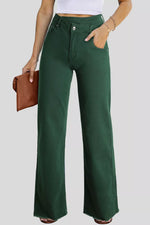 Person wearing green wide-leg pants with a plain background
