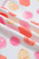 Close-up of fabric with colorful watercolor-like dot pattern on a white background