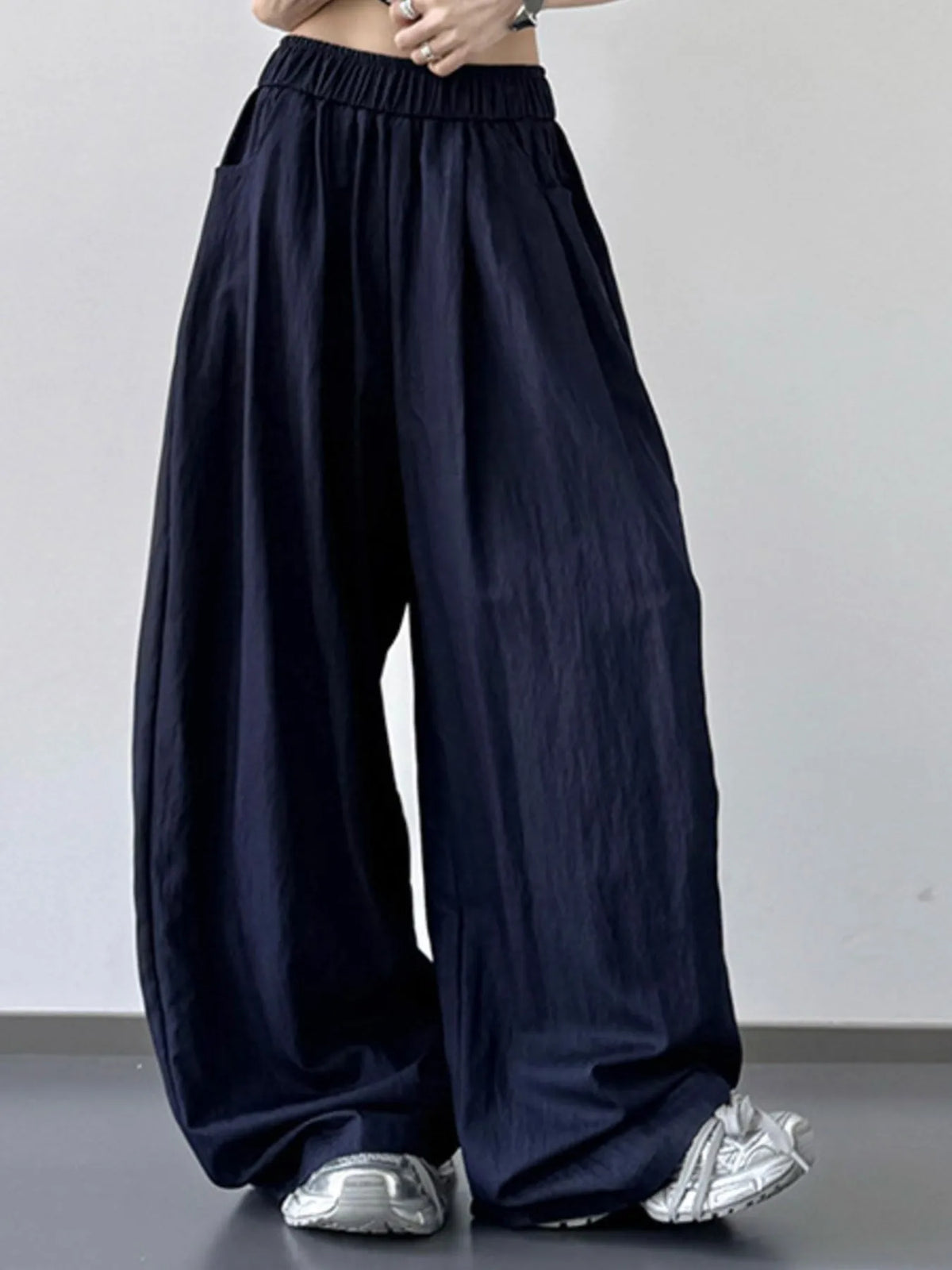 Navy wide-leg pants worn by a person on a plain background