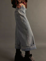 Person wearing light blue denim wide-leg pants on a plain background