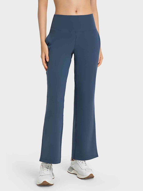 Person wearing blue high-waisted pants on a white background