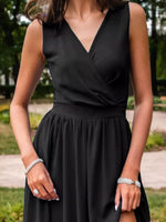 Person wearing a black dress with a blurred outdoor background
