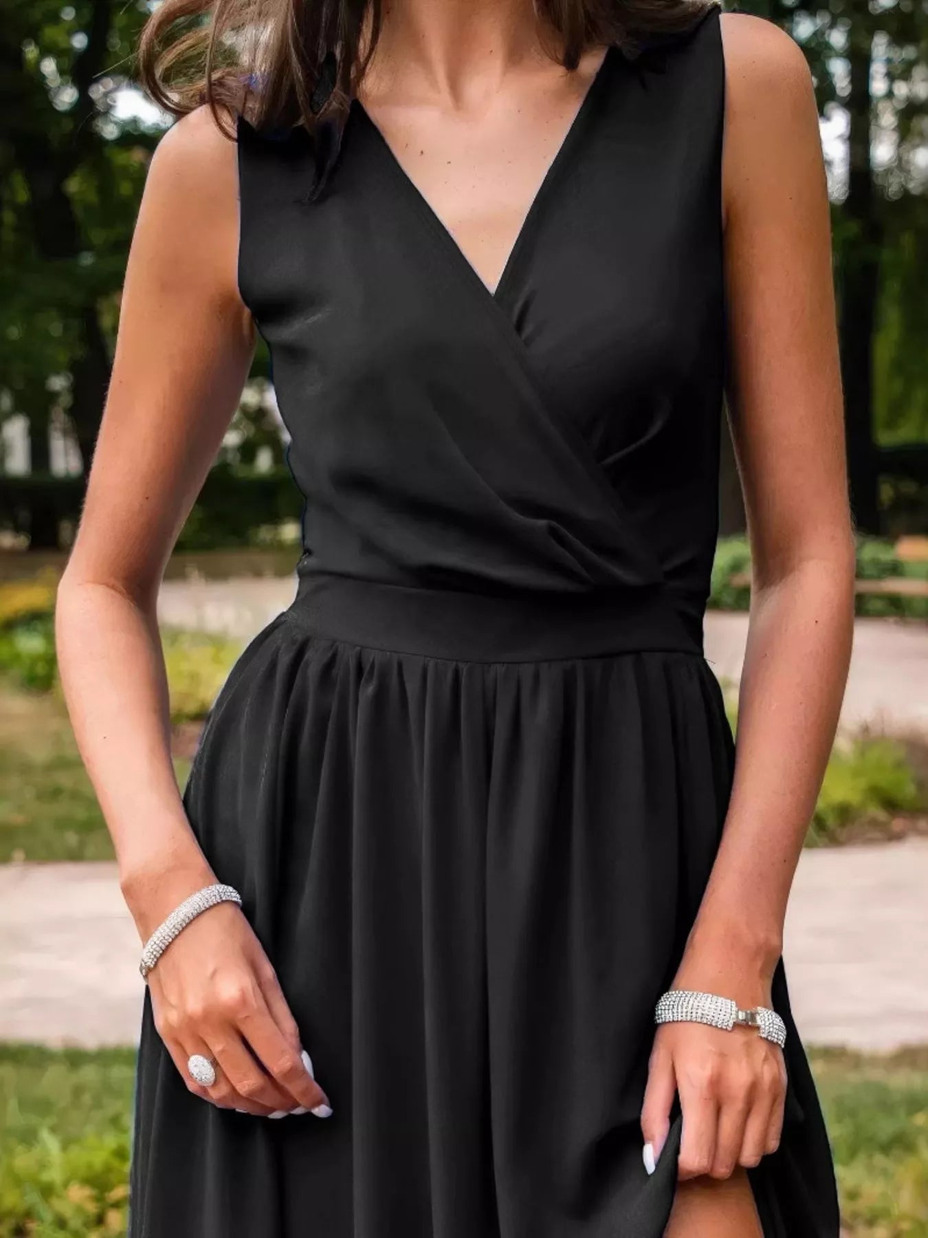 Person wearing a black dress with a blurred outdoor background