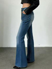Person wearing blue flared jeans with a plain background