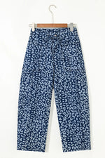 Blue patterned pants on a hanger against a white background